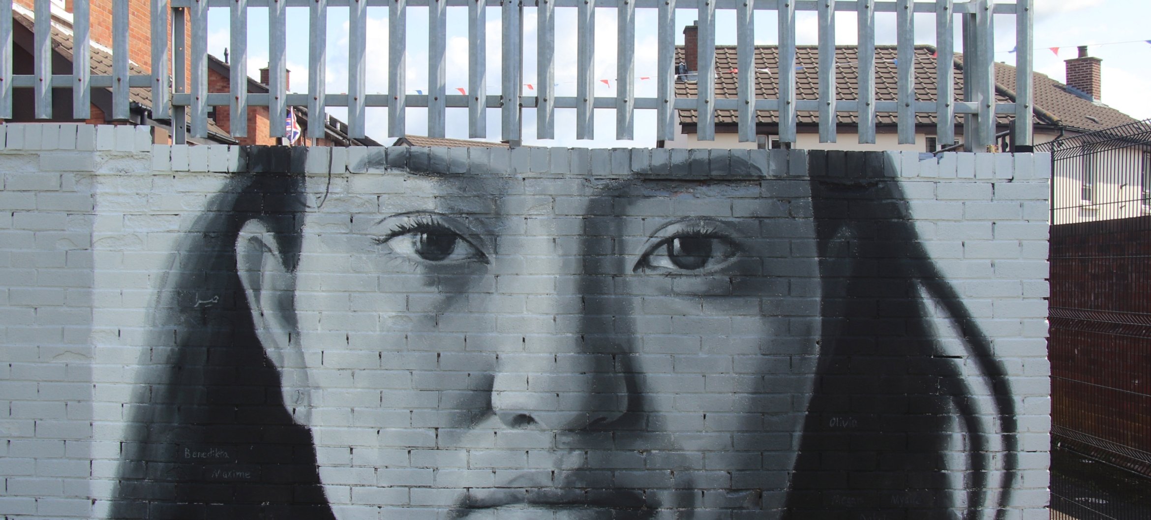 ‘We Are Here’, een muurschildering op de notoire 'Peace Wall' in Belfast, door iMAE-alumnus Leyli Rashidirauf. De Peace Wall loopt dwars langs de Shankill Mission, een belanrgijke thuisbasis voor artisteducator-studenten bij ArtEZ. Foto door Brian Kelly
