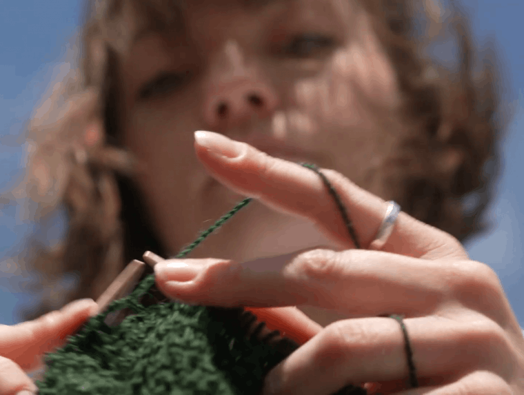 Andrea van der Kuil knitting during her graduation performance. Still from video